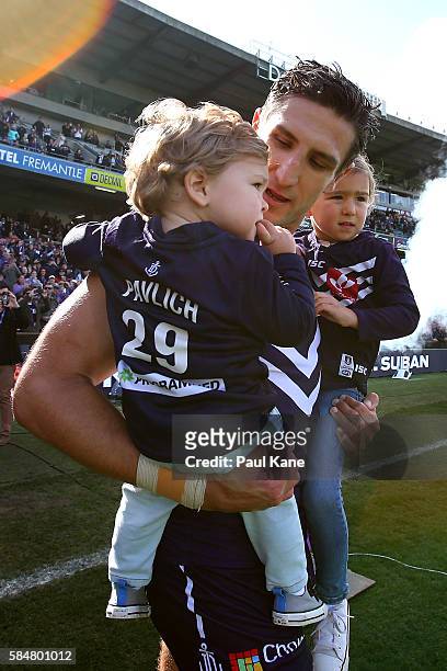 Matthew Pavlich of the Dockers walks out onto the field with his son Jack and daughter Harper to play his 350th game during the round 19 AFL match...