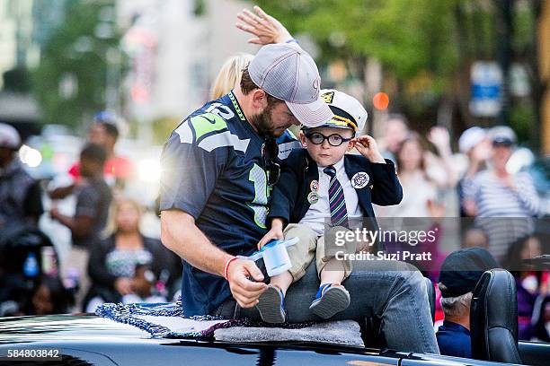 Actor Chris Pratt and son Jack Pratt ride in the Seafair Torchlight Parade Grand Marshal vehicle on July 30, 2016 in Seattle, Washington.