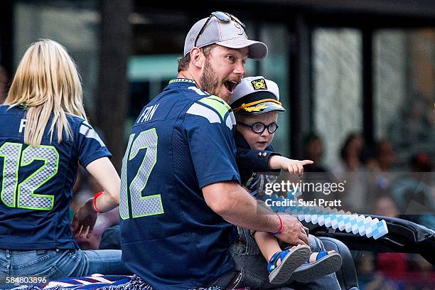 Actor Chris Pratt and son Jack Pratt ride in the Seafair Torchlight Parade Grand Marshal vehicle on July 30, 2016 in Seattle, Washington.