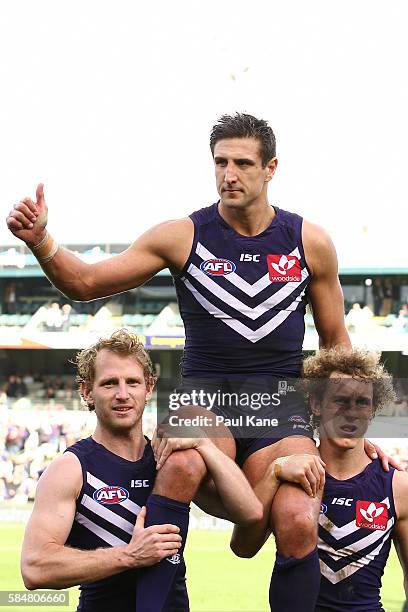 Matthew Pavlich of the Dockers is chaired from the ground by David Mundy and Chris Mayne after playing his 350th game during the round 19 AFL match...