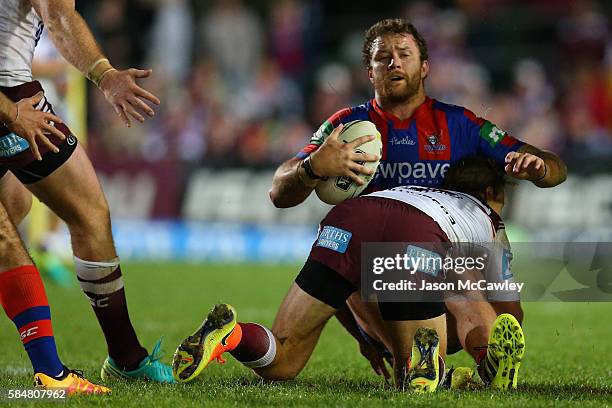 Korbin Sims of the Knights is tackled during the round 21 NRL match between the Manly Sea Eagles and the Newcastle Knights at Brookvale Oval on July...