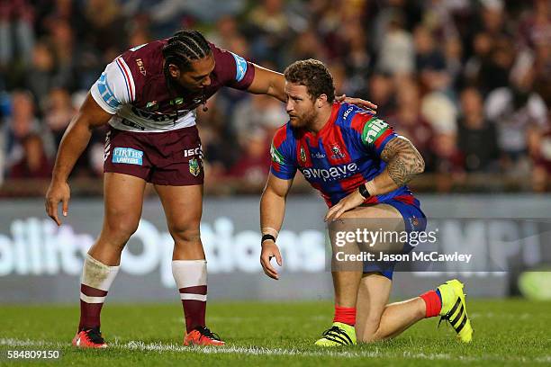 Martin Taupau of the Sea Eagles checks on Korbin Sims of the Knights during the round 21 NRL match between the Manly Sea Eagles and the Newcastle...