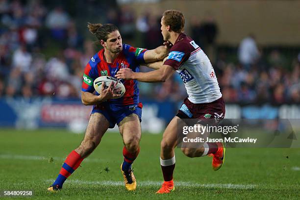 Jake Mamo of the Knights is tackled by Daly Cherry-Evans of the Sea Eagles during the round 21 NRL match between the Manly Sea Eagles and the...