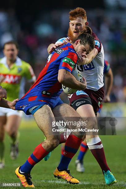 Jake Mamo of the Knights is tackled by Nathan Green of the Sea Eagles during the round 21 NRL match between the Manly Sea Eagles and the Newcastle...