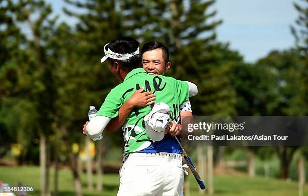 Chan Shih-chang of Chinese Taipei is congratulated on the 18th green by fellow player Lin Wen-tang of Chinese Taiep during round four of the King's...