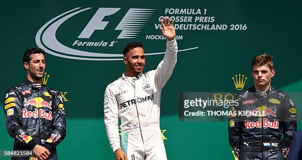 Mercedes AMG Petronas F1 Team's British driver Lewis Hamilton waves after winning next to second placed Red Bull Racing's Australian driver Daniel...