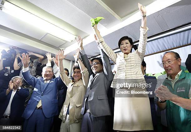 Yuriko Koike, former Japanese Defense Minister and a candidate for the Tokyo governor, right, celebrates with her supporters after winning the Tokyo...