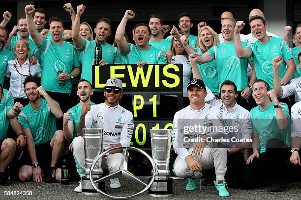 Lewis Hamilton of Great Britain and Mercedes GP celebrates with his team including Nico Rosberg of Germany and Mercedes GP outside the garage after...