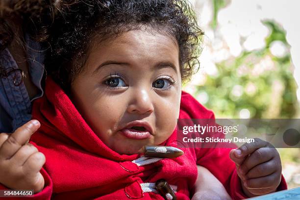 latin and black baby girl in mother's arms with attitude_3319 - baby middle finger photos et images de collection