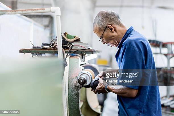 man making shoes at a factory - shoe repair stockfoto's en -beelden