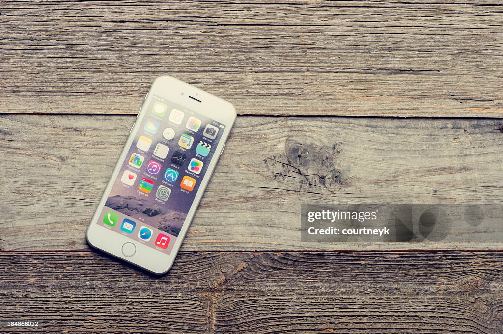 Smart phone on a wood table or surface.