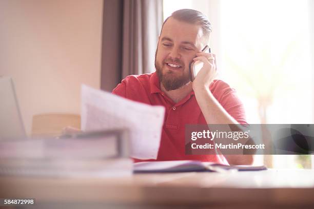 glücklich männlich am telefon mit ihrer hypothekenfirma - schuldenberatung stock-fotos und bilder