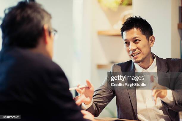 two men in a casual meeting in a cafe - business meeting cafe stock pictures, royalty-free photos & images