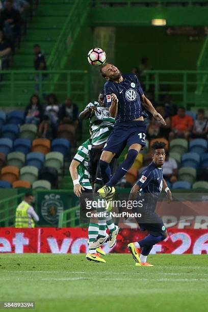 Wolfsburg's forward Bas Dost heads the ball with Sporting's midfielder William Carvalho during the Trofeu Cinco Violinos football match Sporting CP...