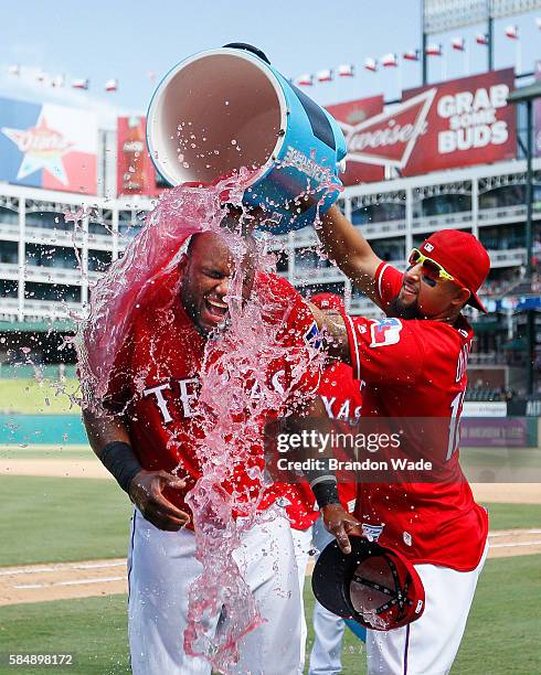 Hanser Alberto of the Texas Rangers, left, reacts to a sports drink shower from Rougned Odor in celebration of a 5-3 win over the Kansas City Royals...