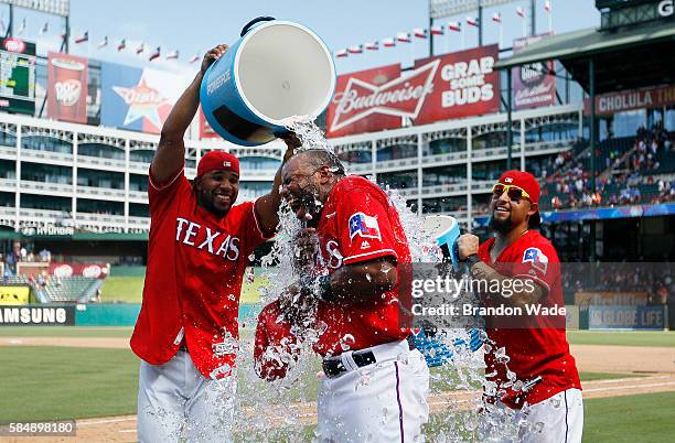 Hanser Alberto of the Texas Rangers, center, reacts to a sports drink shower from Elvis Andrus, left, and Rougned Odor in celebration of a 5-3 win...