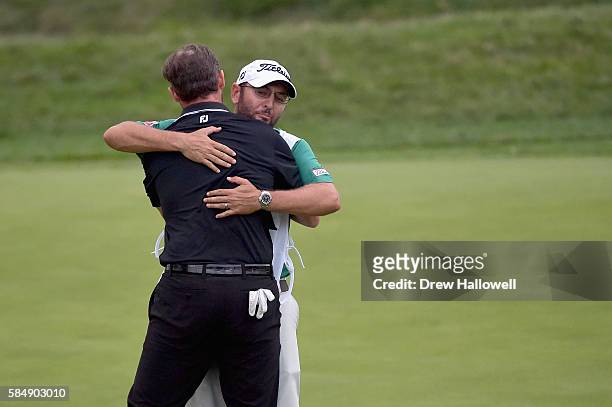 Jimmy Walker of the United States hugs caddie Andy Sanders after his putt for par on the 18th hole to win the 2016 PGA Championship at Baltusrol Golf...