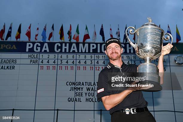 Jimmy Walker of the United States celebrates with the Wanamaker Trophy in front of the leaderboard after winning the 2016 PGA Championship at...