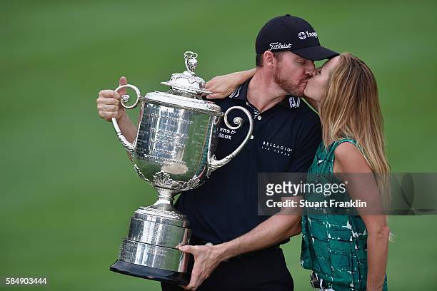 Jimmy Walker of the United States kisses his wife Erin while holding with the Wanamaker Trophy in celebration of his victory during the 2016 PGA...