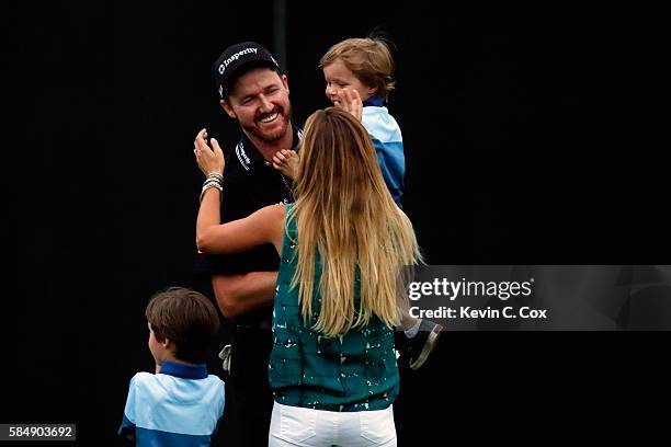 Jimmy Walker of the United States celebrates with his wife Erin and sons Beckett and Mclain after making par on the 18th hole to win the 2016 PGA...