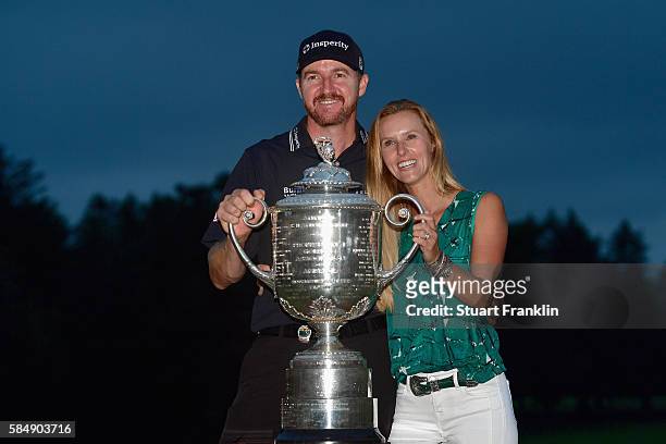 Jimmy Walker of the United States celebrates with his wife Erin while holding with the Wanamaker Trophy after his victory during the 2016 PGA...