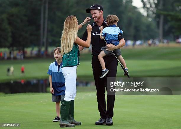 Jimmy Walker of the United States celebrates with his wife Erin and sons Beckett and Mclain after making par on the 18th hole to win the 2016 PGA...