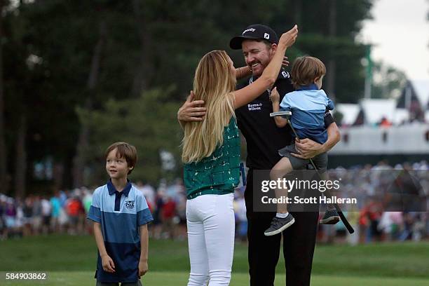 Jimmy Walker of the United States celebrates with his wife Erin and sons Beckett and Mclain after making par on the 18th hole to win the 2016 PGA...