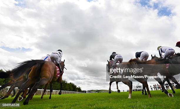View of horses and riders racing out of the starting stalls during competition in the Qatar King George Stakes at the Qatar Goodwood Festival at...