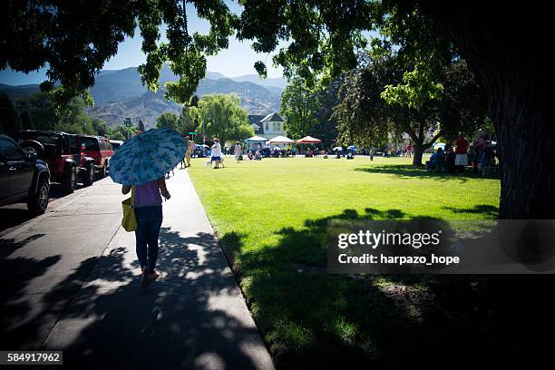 girl walking with a parasol. - small town community stock pictures, royalty-free photos & images