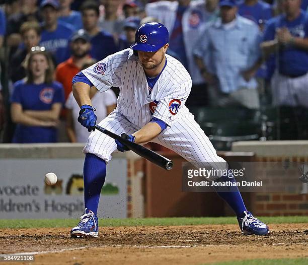 Jon Lester of the Chicago Cubs bunts in the winning run against the Seattle Mariners at Wrigley Field on July 31, 2016 in Chicago, Illinois. The Cubs...