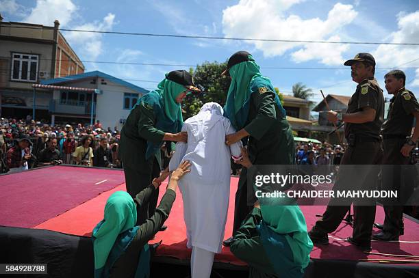 religious-officers-bring-an-acehnese-youth-onstage-before-a-public-caning-event-as-punishment.jpg?s=612x612&w=gi&k=20&c=OoYbpFW__6-au2KnObI30N2xlVP1-WVVmcf2C5ceMUw=