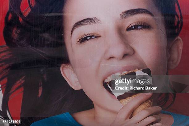 Detail of an advert - a picture of a girl enjoying an ice cream cone with chocolate chips seemingly the shape of bad teeth, on 12th July 2016, at...