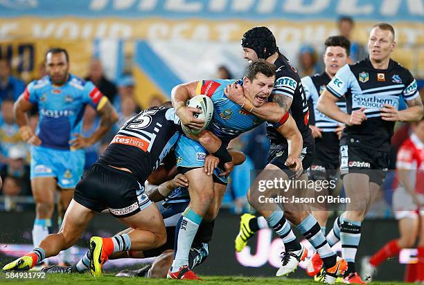 Greg Bird of the Titans is tackled by Michael Ennis of the Sharks during the round 21 NRL match between the Gold Coast Titans and the Cronulla Sharks...