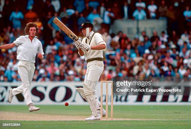 Rick McCosker of Australia, batting with the bandaged broken jaw which he suffered in the first innings, faces Bob Willis of England in the second...