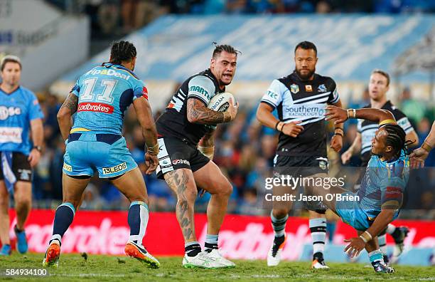 Andrew Fifita of the Sharks bumps off Agnatius Paasi of the Titans during the round 21 NRL match between the Gold Coast Titans and the Cronulla...