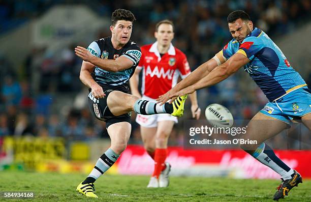 Chad Townsend of the Sharks has a field goal attempt charged down by Ryan James during the round 21 NRL match between the Gold Coast Titans and the...