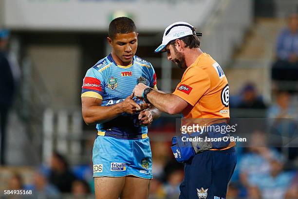 David Mead of the Titans receives treatment for an injury during the round 21 NRL match between the Gold Coast Titans and the Cronulla Sharks at Cbus...