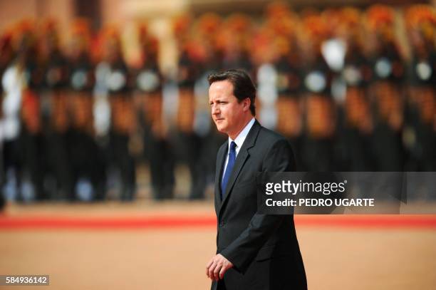 British Prime Minister David Cameron inspects an honour guard at the Presidential Palace in New Delhi on July 29, 2010. Cameron, accompanied by a...