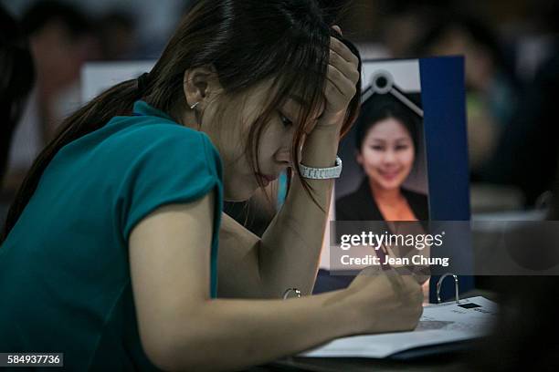 Participants write their biography and the words on their own tombstone while looking at their own funeral photos in a "Death Experience/Fake...