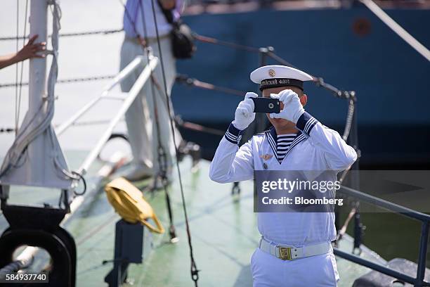 Baltic Fleet sailor takes a photograph with a smartphone aboard the Parchim class corvette Kalmykia MPK 229 warship during Russian Navy day at the...