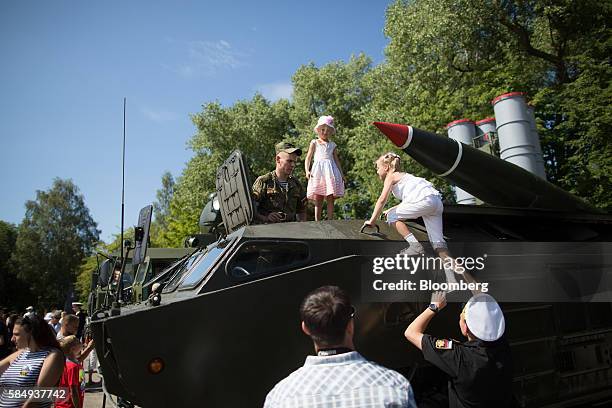 Children climb aboard a 9K79 Tochka ballistic missile carrier at a display of Russian army military hardware during Russian Navy day at the Vistula...