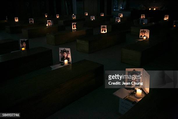Funeral photos of the participants of "Death Experience/Fake Funeral" are illuminated by candle lights on the coffins on August 1, 2016 in Andong,...