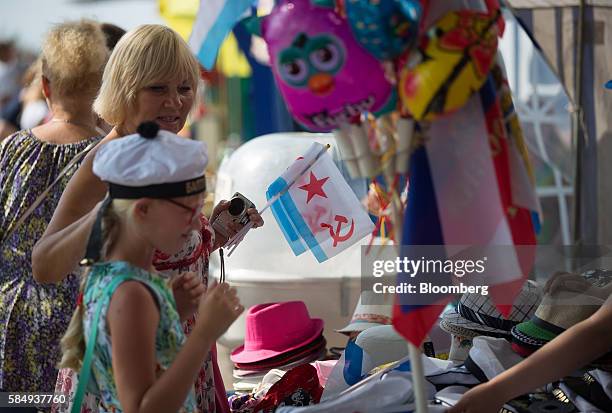 Visitor purchases souvenir old Soviet era Navy flags from a street stall during Russian Navy day at the Vistula lagoon in Baltiysk, Russia, on...