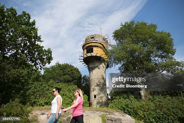 Visitors pass an old abandoned German pillbox, once disguised as a water tower, overlooking the Vistula lagoon where the Russian Baltic Fleet is...