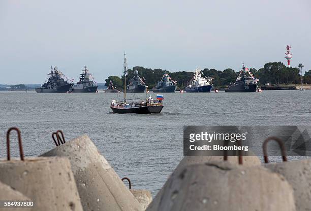 Sailing boat flying a Russian national flag passes warships of the Baltic Fleet at the Vistula lagoon in Baltiysk, Russia, on Sunday, July 31, 2016....