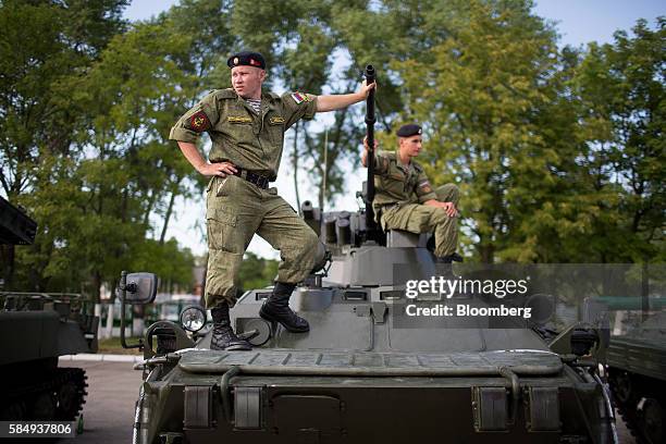 Russian army soldiers wait to supervise visitors at a display of military vehicles during Russian Navy day at the Vistula lagoon in Baltiysk, Russia,...