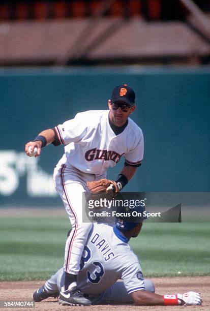 Robby Thompson of the San Francisco Giants holds onto the ball while getting the put out on Eric Davis of the Los Angeles Dodger during an Major...