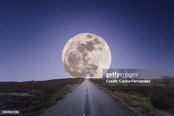 full moon rising over road - medias lunas fotografías e imágenes de stock