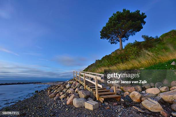 wooden stairs near the water at night - jenco stockfoto's en -beelden