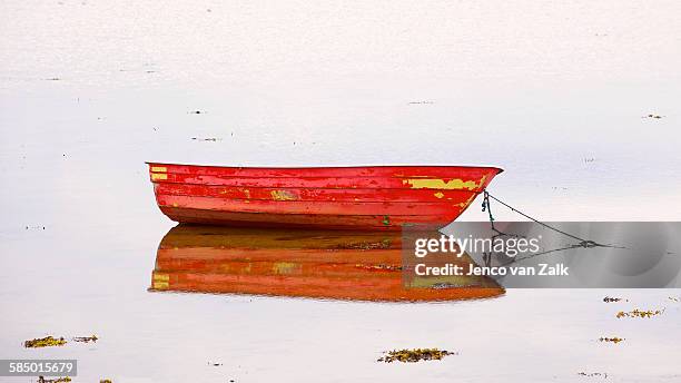 red rowing boat at low tide - jenco stockfoto's en -beelden